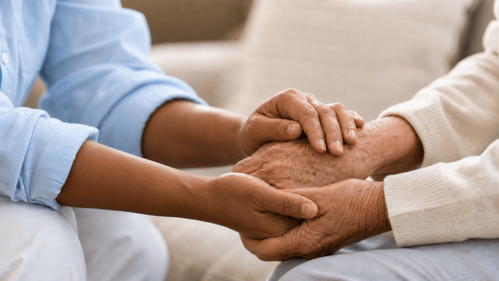 Caregiver gently holding an older adult's hands